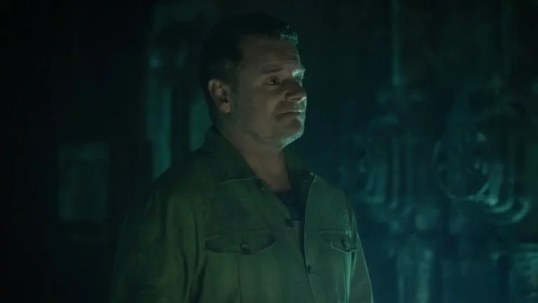 Steve Zahn as Solo/Jimmy looking hopeful in a dark, teal-lit industrial corridor in Silo.