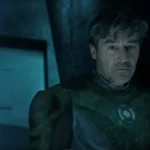 Kyle Chandler as Hal Jordan wearing a Green Lantern suit with a circular chest emblem under blue lighting.