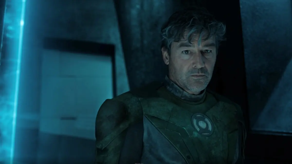 Kyle Chandler as Hal Jordan wearing a Green Lantern suit with a circular chest emblem under blue lighting.