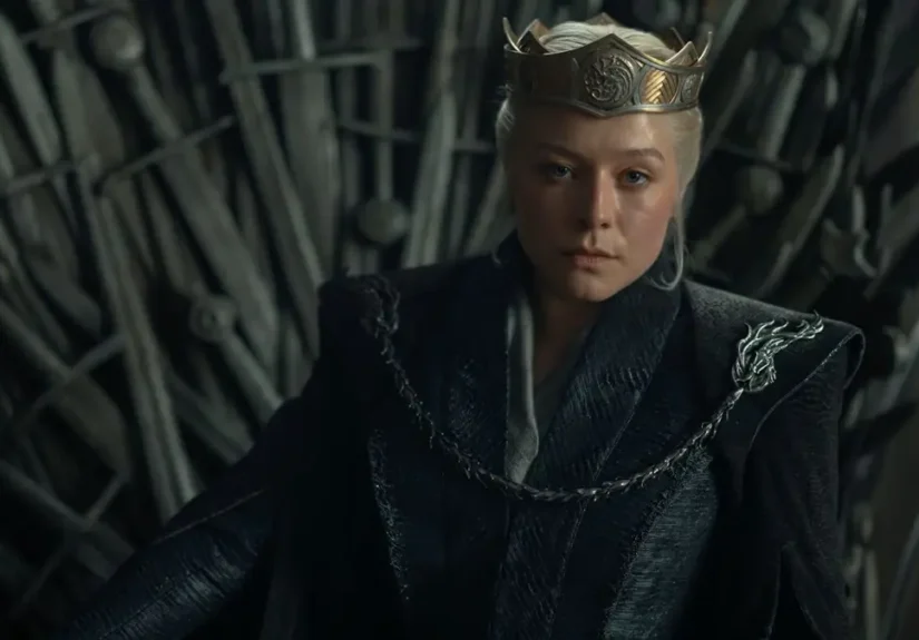 Emma D'Arcy as Queen Rhaenyra Targaryen wearing a crown while seated on the Iron Throne in House of the Dragon.