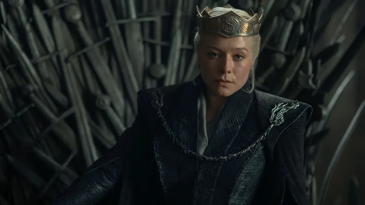 Emma D'Arcy as Queen Rhaenyra Targaryen wearing a crown while seated on the Iron Throne in House of the Dragon.