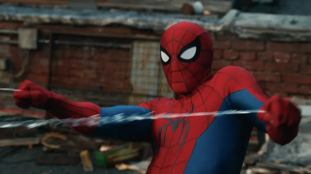 Spider-Man in his classic red and blue suit shooting web-lines horizontally across a rooftop.