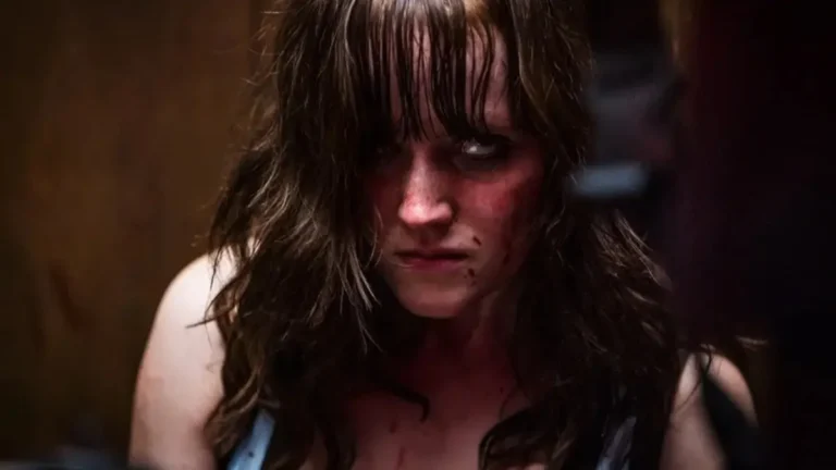 Markella Kavenagh as Eden with bloody smudges on her face and damp hair framing a fierce, intense expression in the film Kick On.
