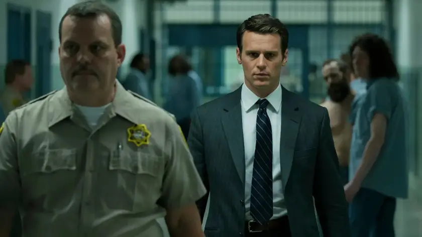 Jonathan Groff as FBI agent Holden Ford alongside a correctional officer in a scene from the Netflix crime drama series Mindhunter.