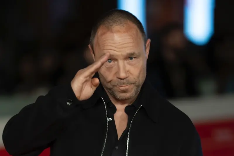 Stephen Graham saluting on a red carpet.