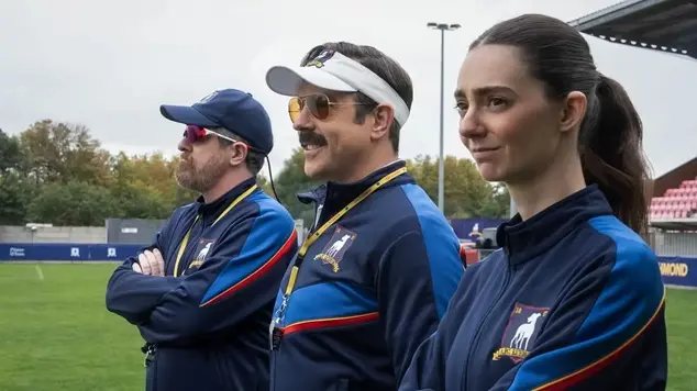 The coaching trio from Season 4 of the Apple TV+ comedy series Ted Lasso, featuring Brendan Hunt as Coach Beard, Jason Sudeikis as Ted Lasso, and Tanya Reynolds as assistant coach Alice Chilton