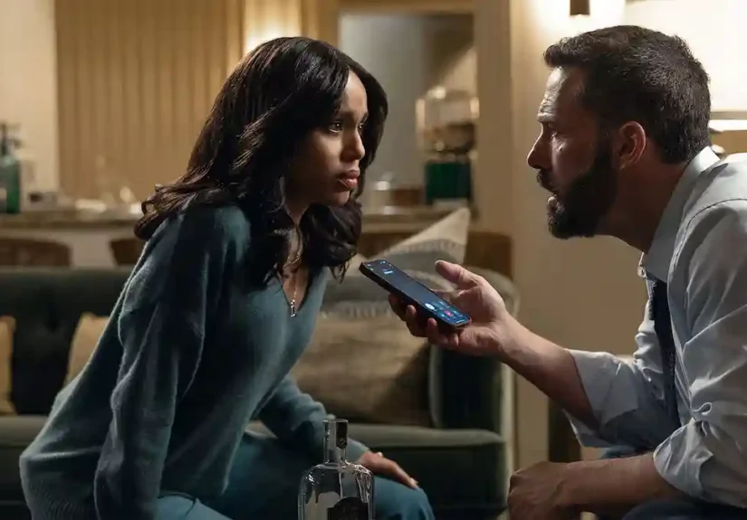 Kerry Washington and Ben Affleck look intensely at a smartphone he is holding up in an indoor living room scene from the film Animals.