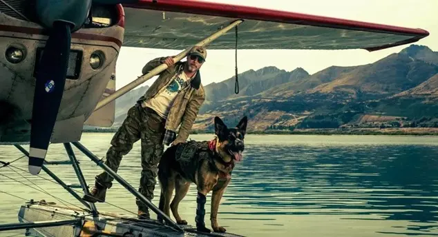 Brad Pitt alongside a German Shepherd named Uber in a scene from the survival thriller film Heart of the Beast.