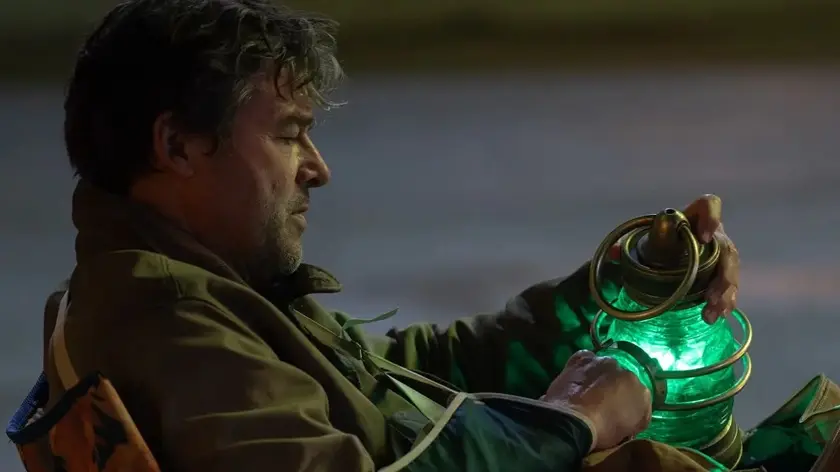 Kyle Chandler as veteran Green Lantern Hal Jordan holding a green power battery in the HBO series Lanterns.
